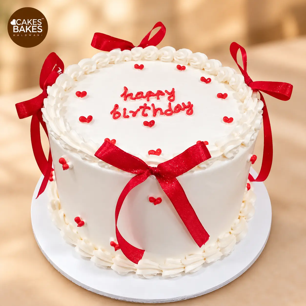 Elegant White Birthday Cake with Red Bows — 100% eggless cake by Cakes & Bakes Haldwani